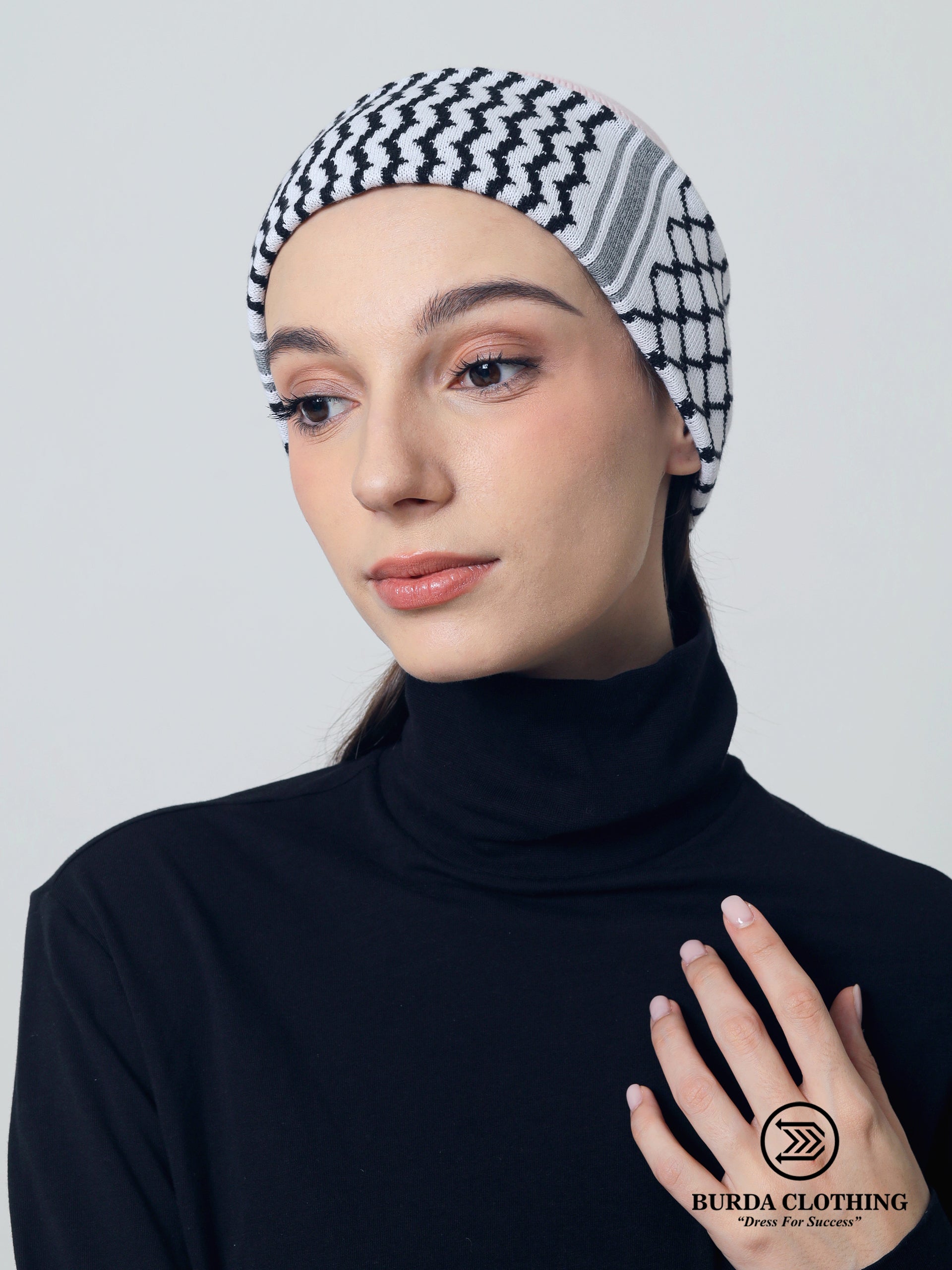 Woman wearing a black and pink checkered beanie with Burda Clothing logo.