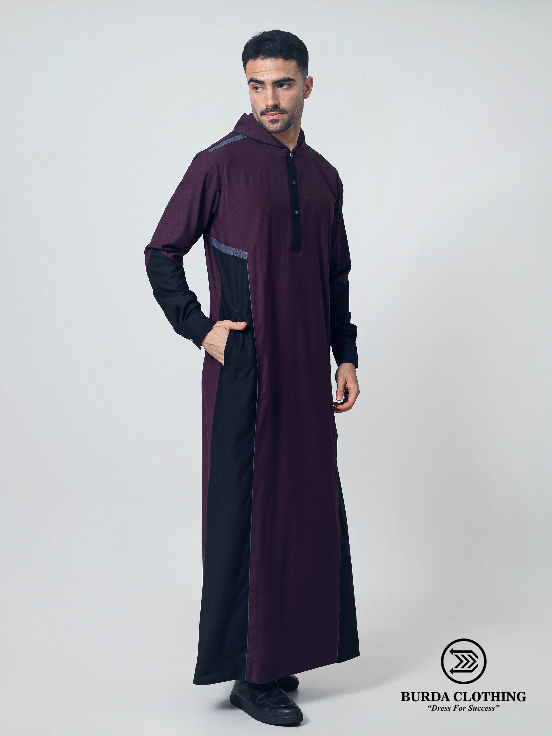 Man wearing a long dark purple garment with black accents on a white background, featuring the Burda Clothing brand.