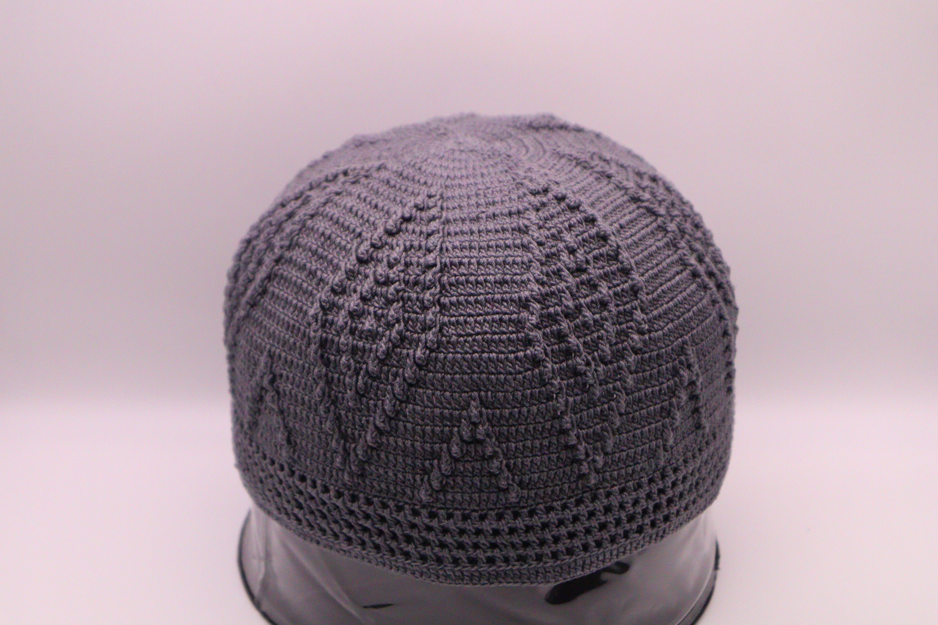 Gray knitted cap on a mannequin head against a white background